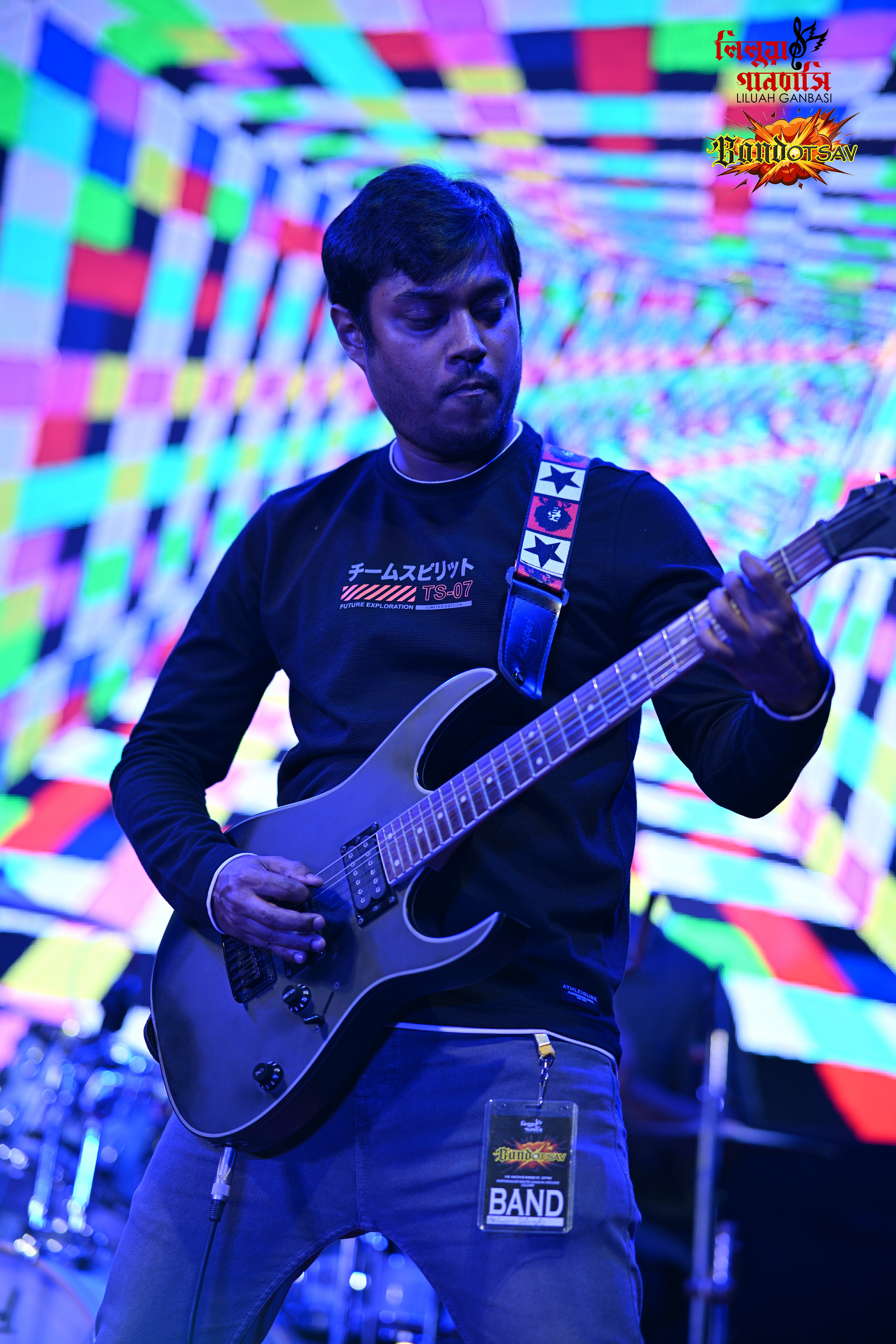 Between Blanks guitarist performing under colorful lights