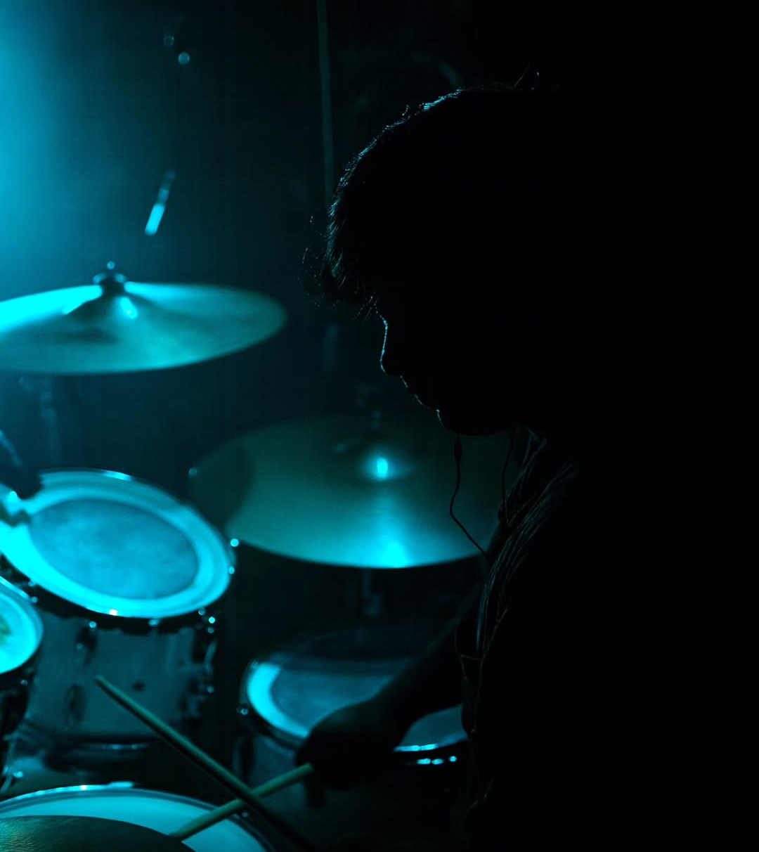 Between Blanks drummer performing under blue light