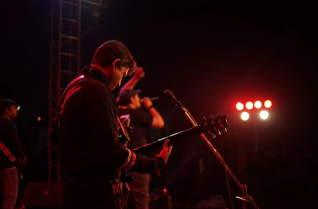 Between Blanks guitarist performing under red light